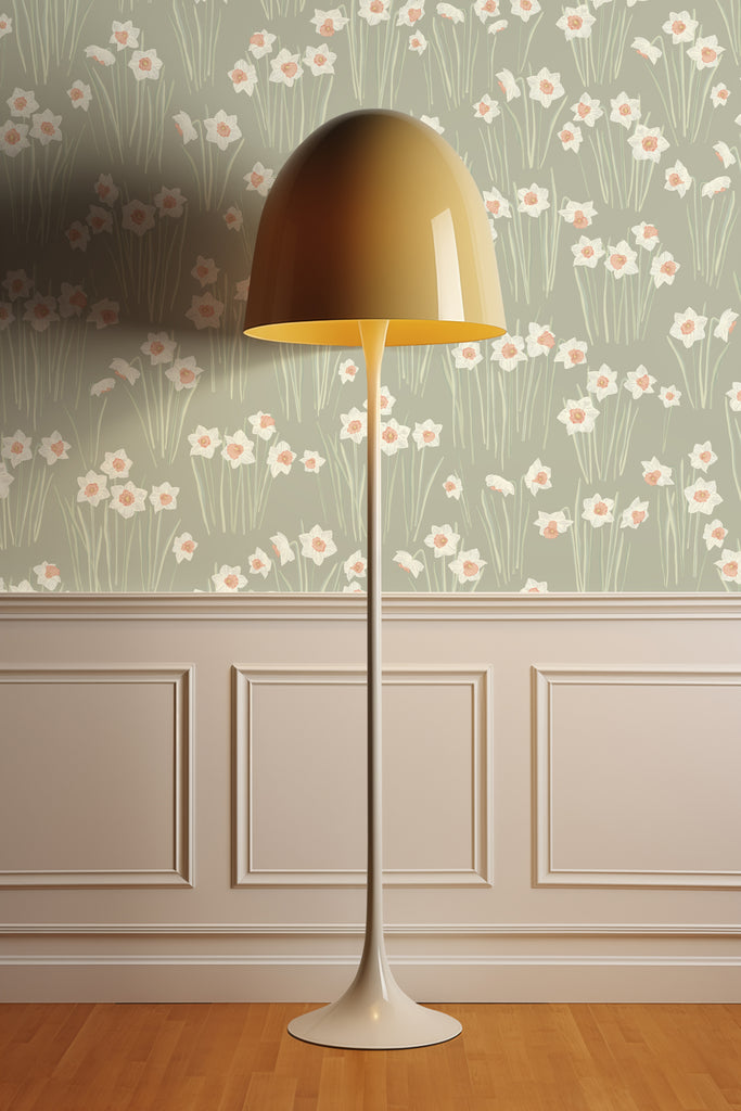 Stylish floor lamp illuminating a room adorned with Daffodil Sage Green wallpaper, featuring a tranquil field of daffodils heralding the start of the spring season.