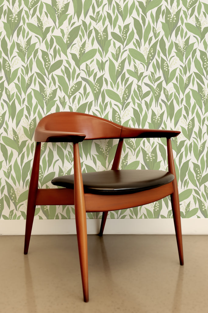 Kate Golding's Lily of the Valley wallpaper creating a serene backdrop to a sleek wooden desk and modern chair.