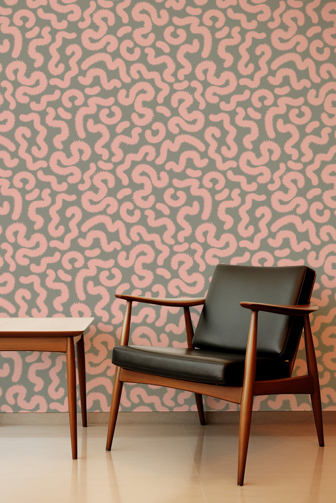 Scandinavian-style leather chair with wooden arms complementing Kate Golding's Spring Pop Pink and Khaki wallpaper, highlighting natural textures.