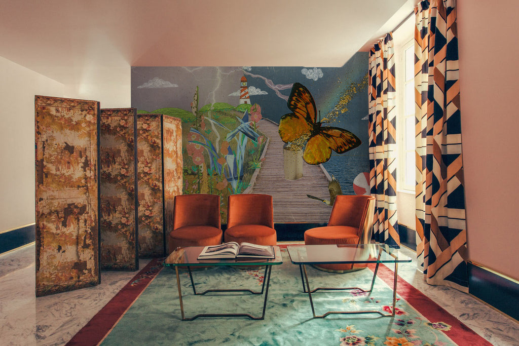 STORYBOARD NO. 13 - RAINBOW’S END wallpaper features a surreal collage with a lighthouse, butterfly, and boardwalk in a vibrant living room setting. Ideal for eclectic interior design, this wallpaper adds whimsical charm to modern spaces.